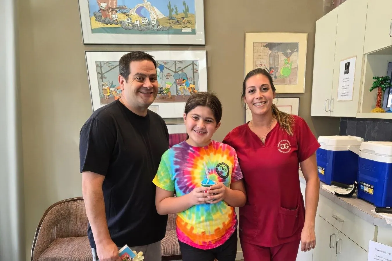 Doctor y asistente con una paciente joven sonriente en el consultorio