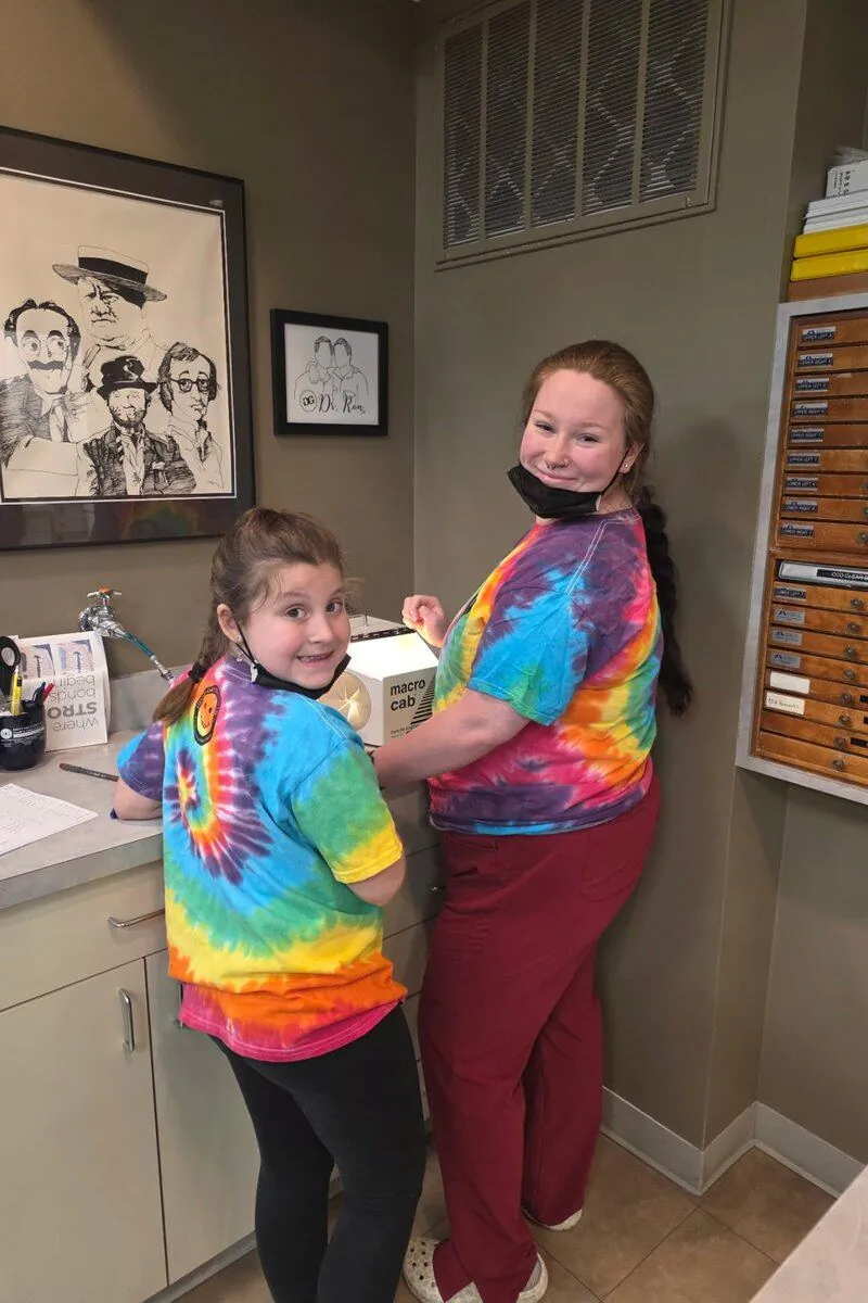 Doyle Orthodontics team members in tie-dye shirts in the office lab